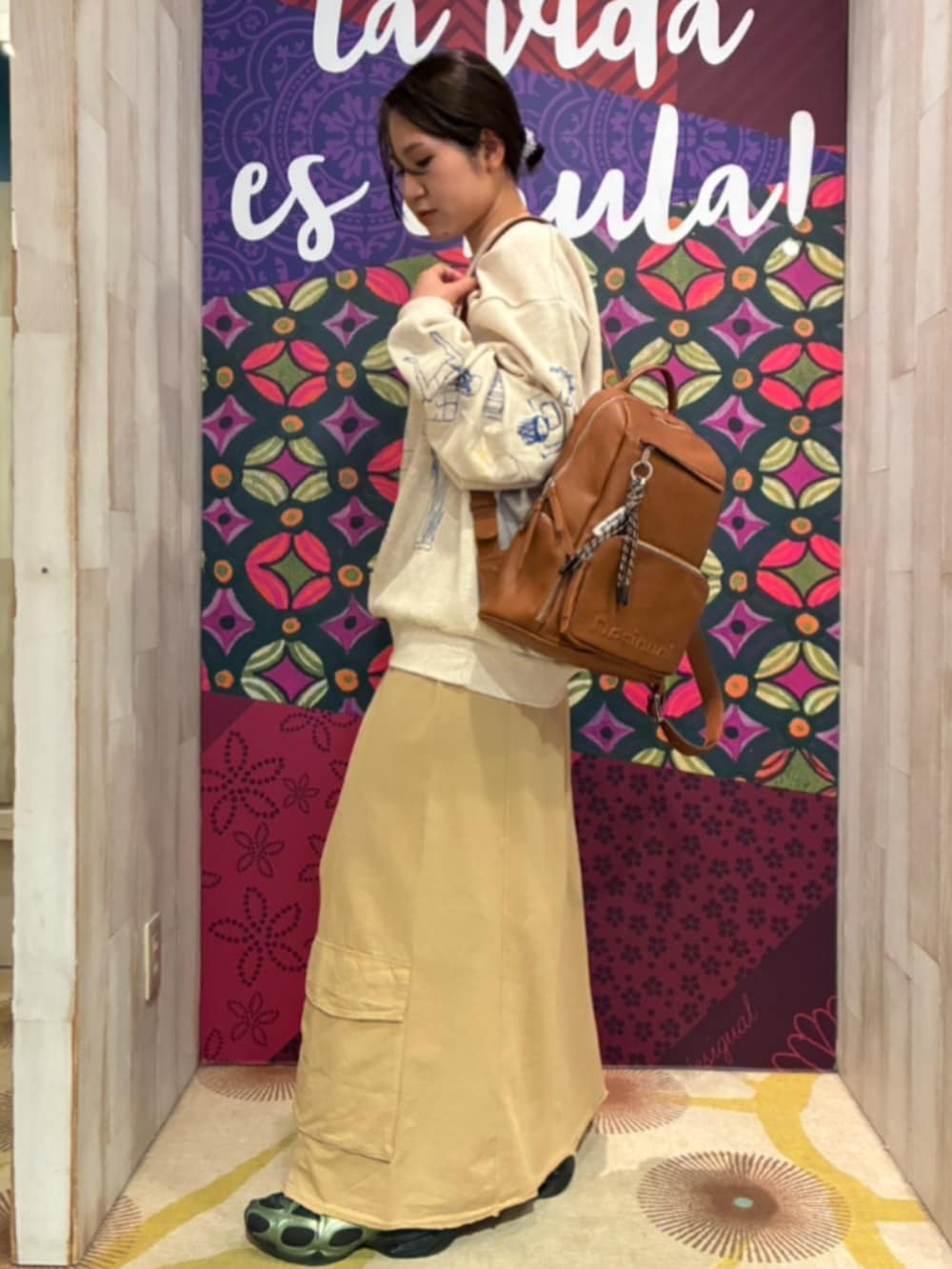 ホワイト系のスウェット、ブラウン系のスカート、ブラウン系のバックパック/リュックを着用したレディースの秋コーディネートの3枚目の写真