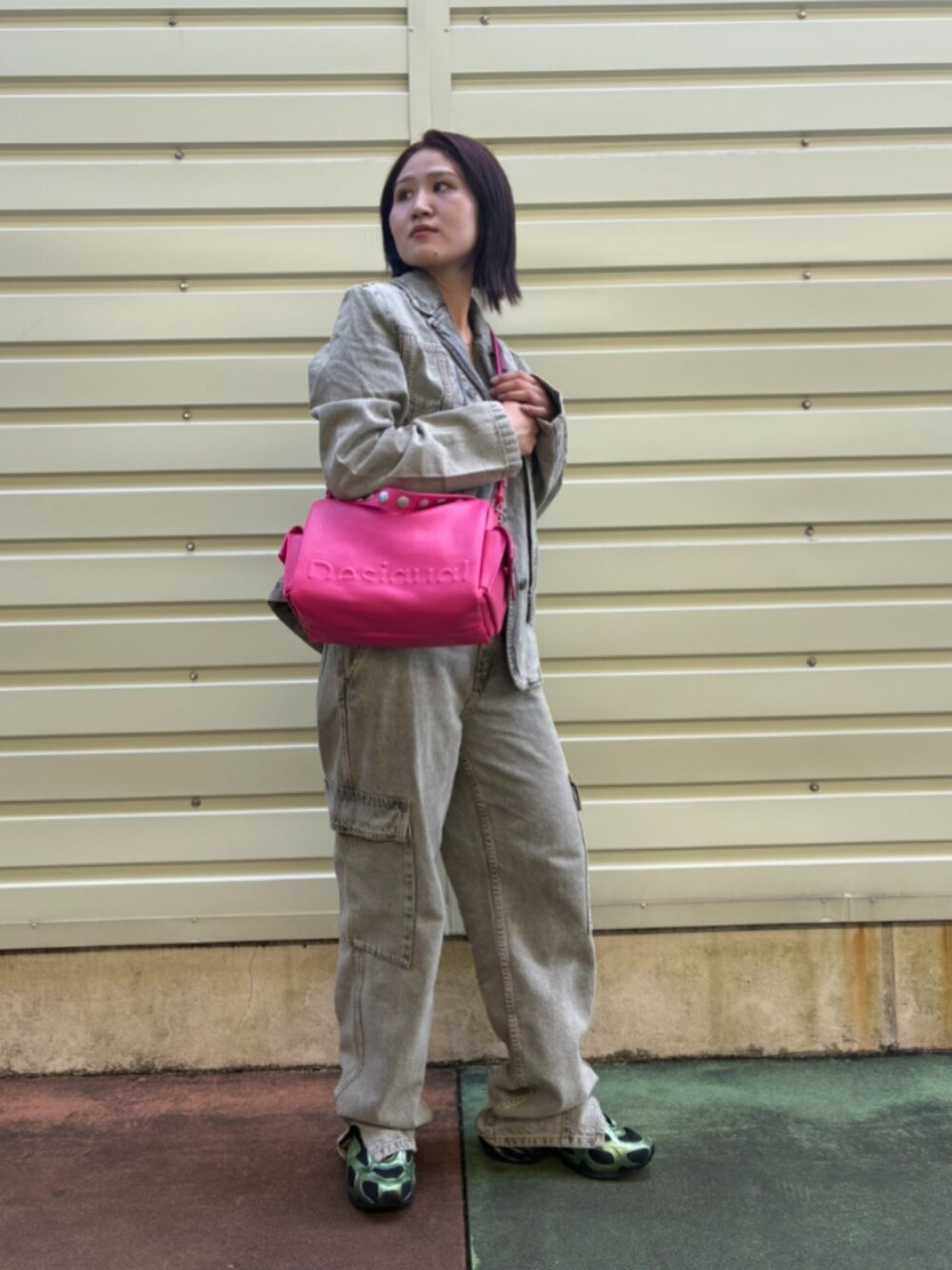 ブラック系のデニムパンツ、ブラック系のデニムジャケット、レッド系のハンドバッグを着用したレディースの秋コーディネートの2枚目の写真