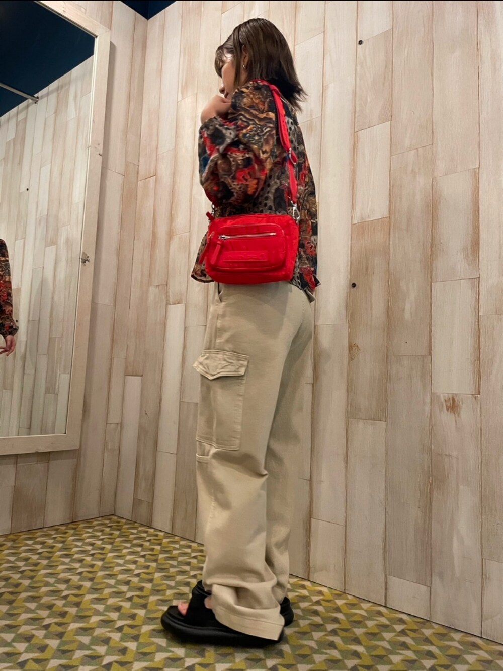 ホワイト系のカーゴパンツ、レッド系のボディバッグ/ウエストポーチ、ブラウン系のシャツ/ブラウスを着用したレディースの夏コーディネートの2枚目の写真