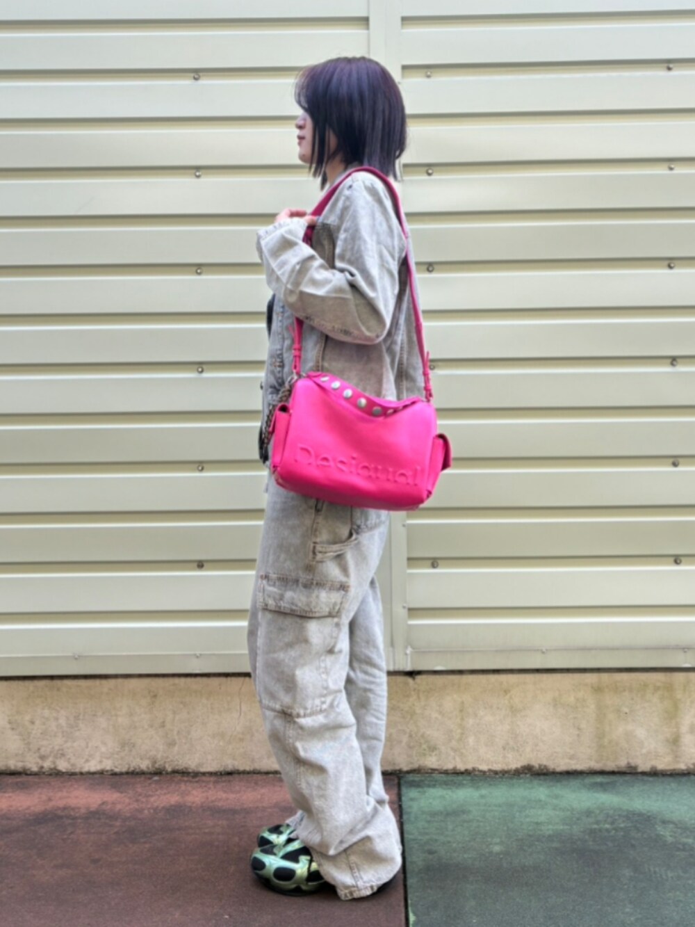 ブラック系のデニムパンツ、ブラック系のデニムジャケット、レッド系のハンドバッグを着用したレディースの秋コーディネートの3枚目の写真