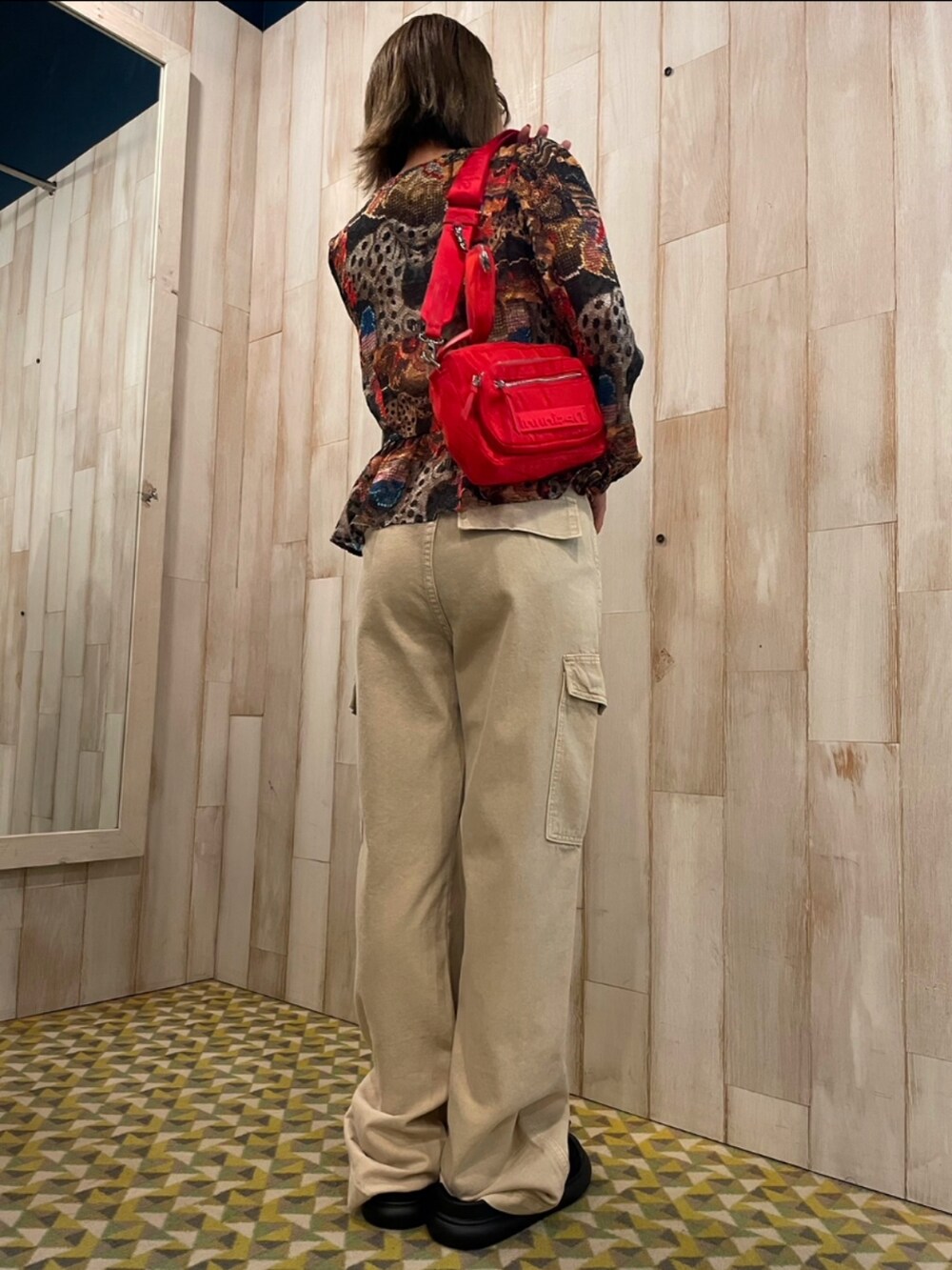 ホワイト系のカーゴパンツ、レッド系のボディバッグ/ウエストポーチ、ブラウン系のシャツ/ブラウスを着用したレディースの夏コーディネートの3枚目の写真