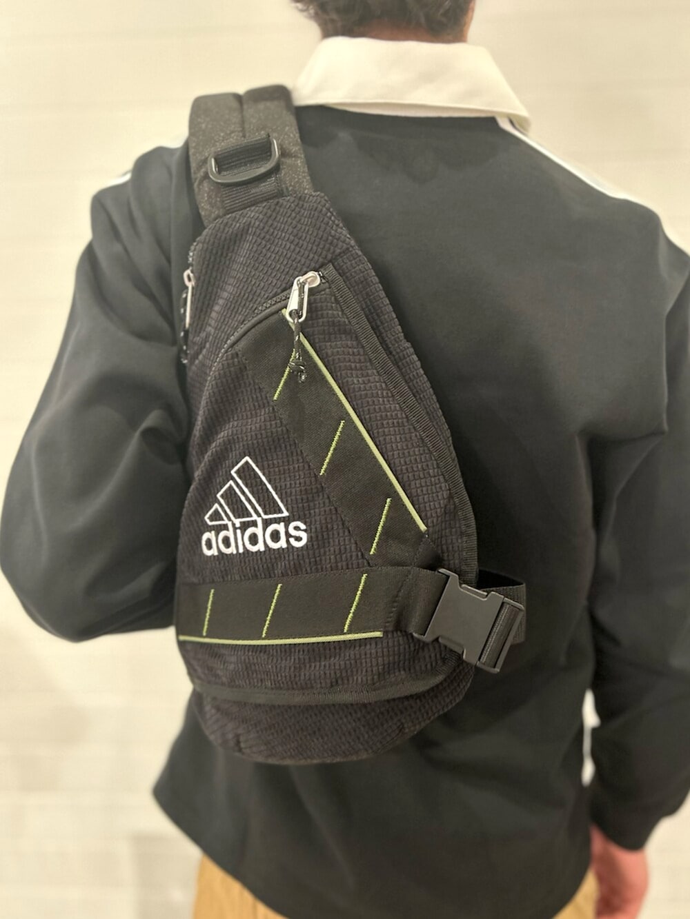 ブラック系のポロシャツ、ブラウン系のその他パンツ、ホワイト系のスニーカーを着用したメンズの秋コーディネートの5枚目の写真