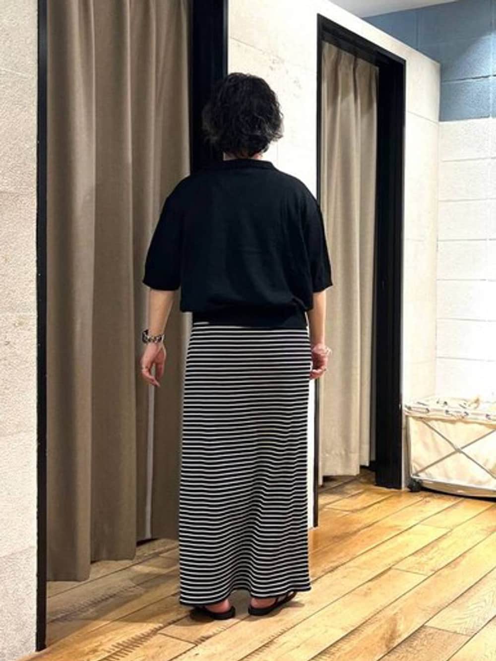 ブラック系のサンダル、ブラック系のTシャツ/カットソー、ブラック系のスカートを着用したレディースの夏コーディネートの3枚目の写真