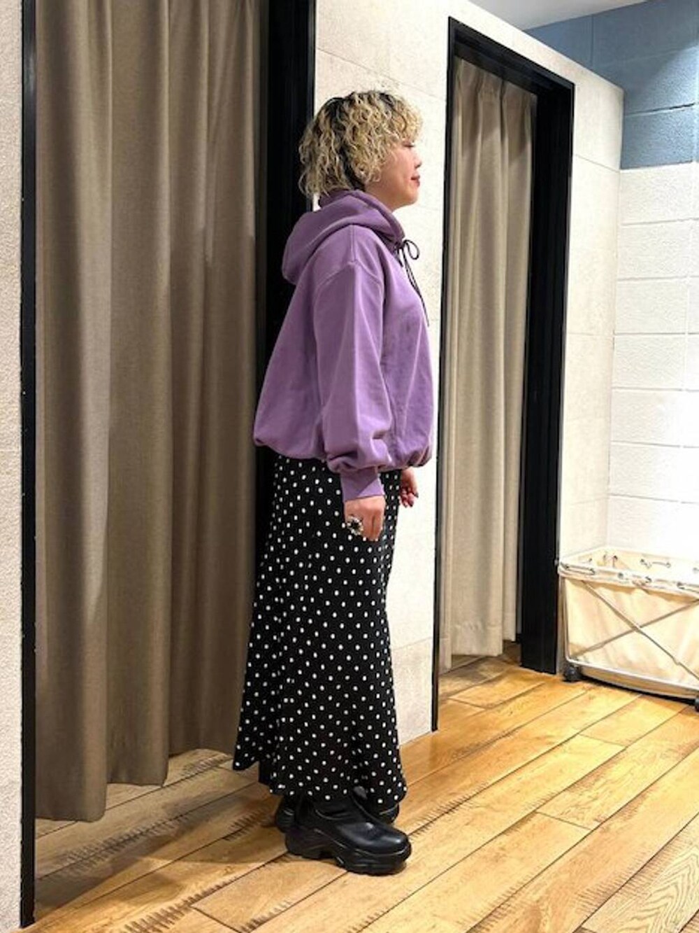 ブラック系のブーツ、ブラック系のスカート、パープル系のパーカーを着用したレディースの秋コーディネートの4枚目の写真