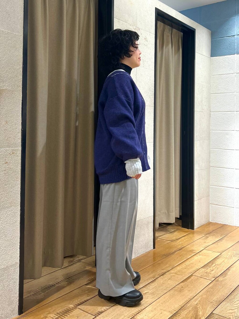 ブラック系のニット/セーター、ブラック系のブーツ、グレー系のサロペット/オーバーオールを着用したレディースの冬コーディネートの4枚目の写真