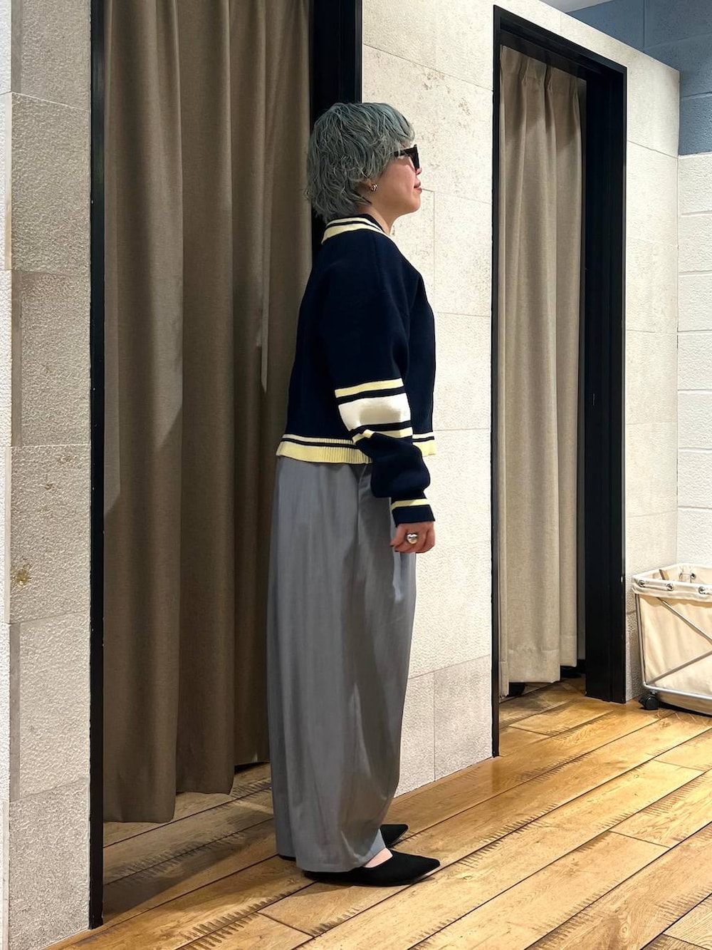 グレー系のその他パンツ、ブラック系のパンプス、ブルー系のニット/セーターを着用したレディースの冬コーディネートの4枚目の写真