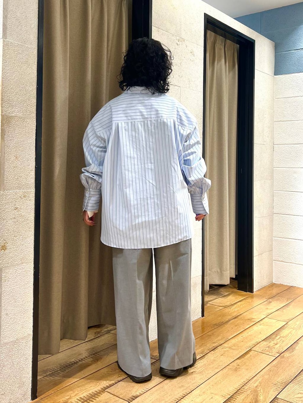 グレー系のサロペット/オーバーオール、ブラック系のブーツ、ブルー系のシャツ/ブラウスを着用したレディースの冬コーディネートの3枚目の写真