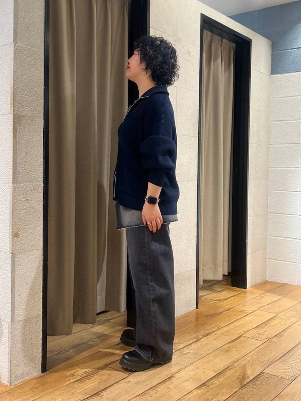 ブラック系のブーツ、ブラック系のデニムパンツ、ブルー系のカーディガン/ボレロを着用したレディースの秋コーディネートの2枚目の写真
