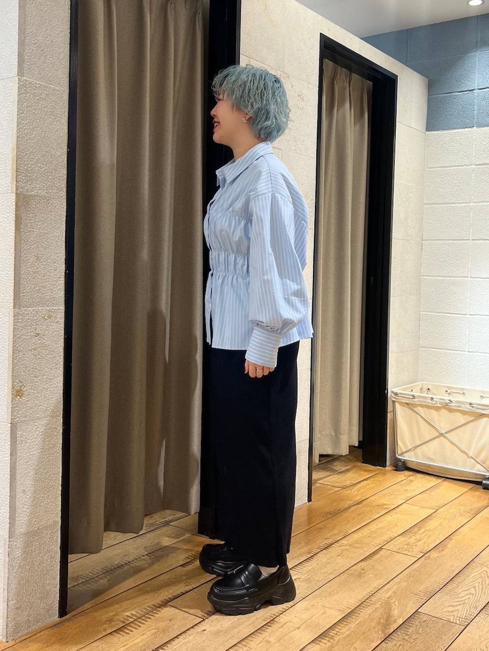 ブラック系のスカート、ブラック系のローファー、ブルー系のシャツ/ブラウスを着用したレディースの冬コーディネートの2枚目の写真