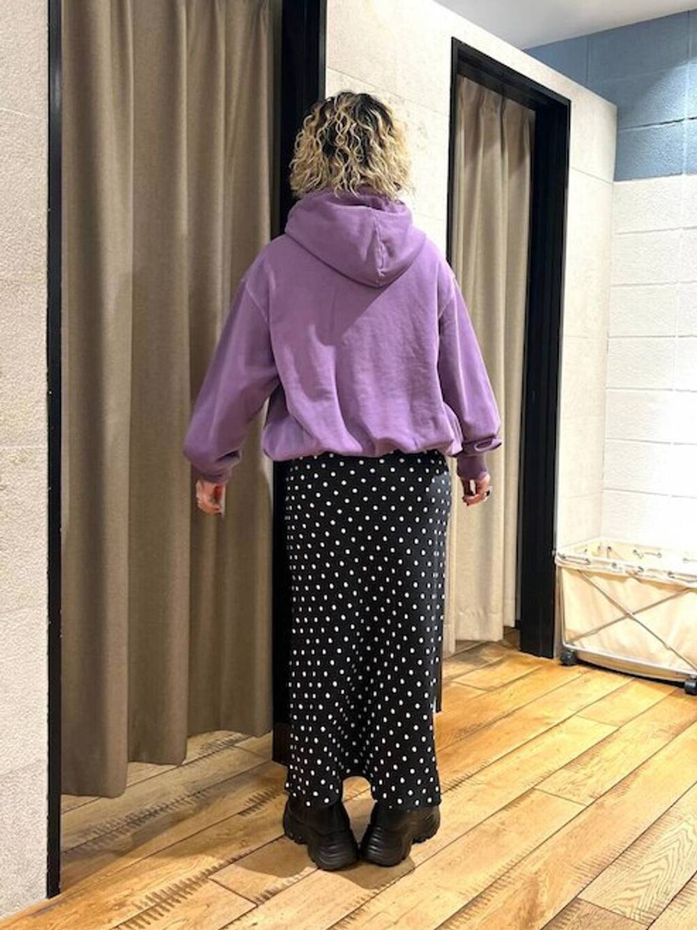 ブラック系のブーツ、ブラック系のスカート、パープル系のパーカーを着用したレディースの秋コーディネートの3枚目の写真