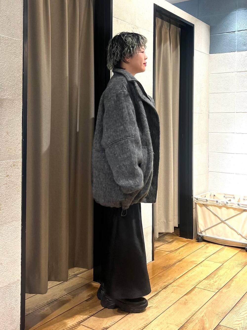 ブラック系のブーツ、ブラック系のスカート、グレー系のその他アウターを着用したレディースの冬コーディネートの4枚目の写真