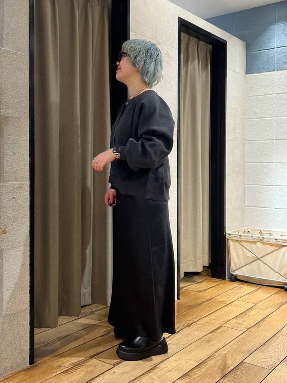 ブラック系のスカート、ブラック系のサンダル、グレー系のカーディガン/ボレロを着用したレディースの冬コーディネートの2枚目の写真