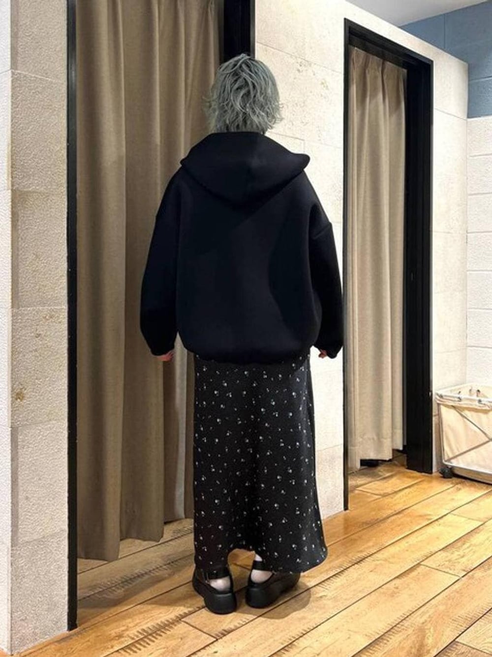 ブラック系のスカート、ブラック系のサンダル、ブラック系のブルゾンを着用したレディースの冬コーディネートの3枚目の写真