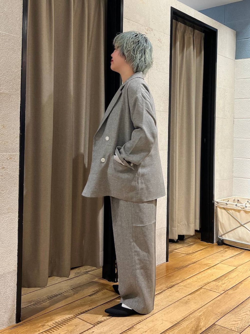 グレー系のテーラードジャケット、グレー系のデニムパンツ、ブラック系のパンプスを着用したレディースの春コーディネートの2枚目の写真