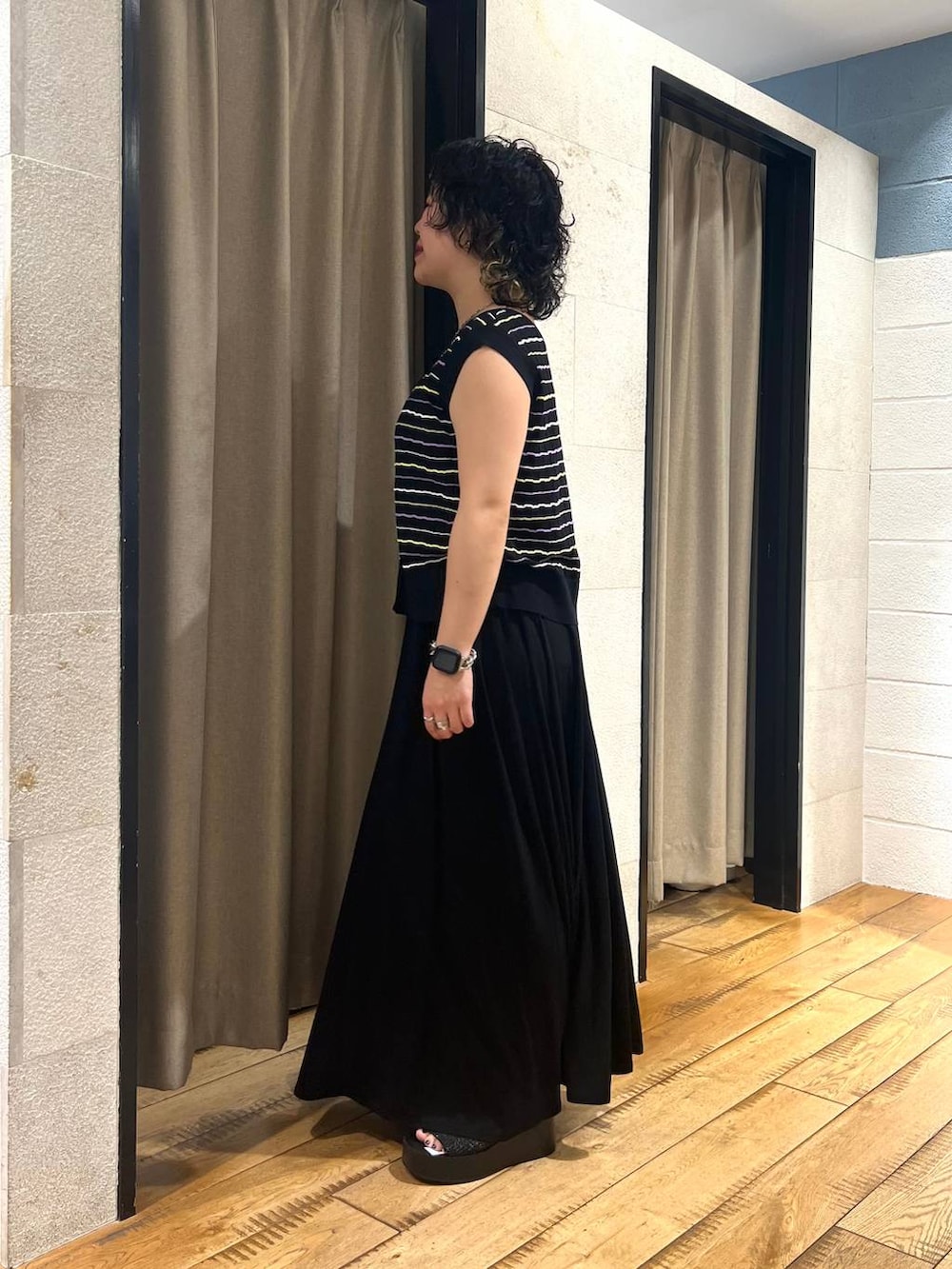 ブラック系のサンダル、ブラック系のスカート、ブラック系のTシャツ/カットソーを着用したレディースの夏コーディネートの2枚目の写真