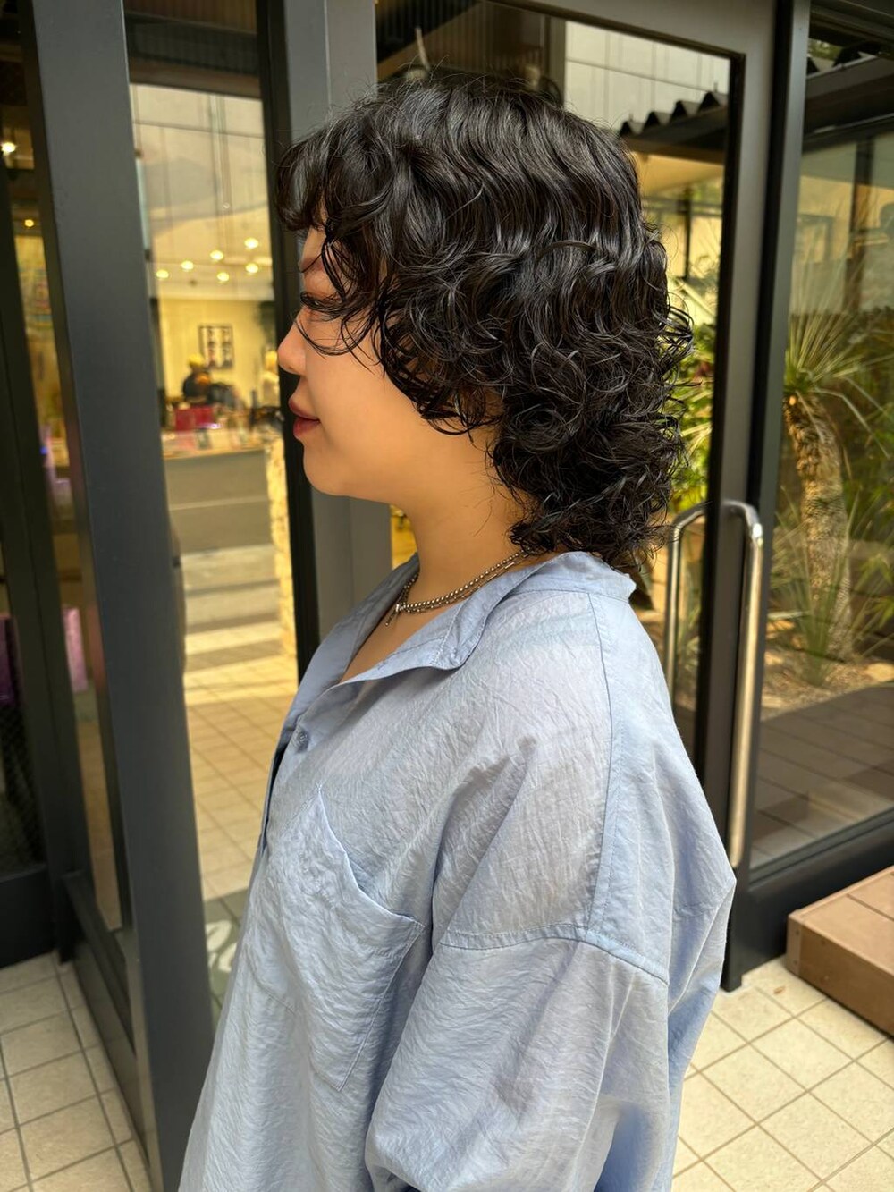 ブラック系のTシャツ/カットソー、ブルー系のシャツ/ブラウス、シルバー系のネックレスを着用したレディースの秋コーディネートの2枚目の写真