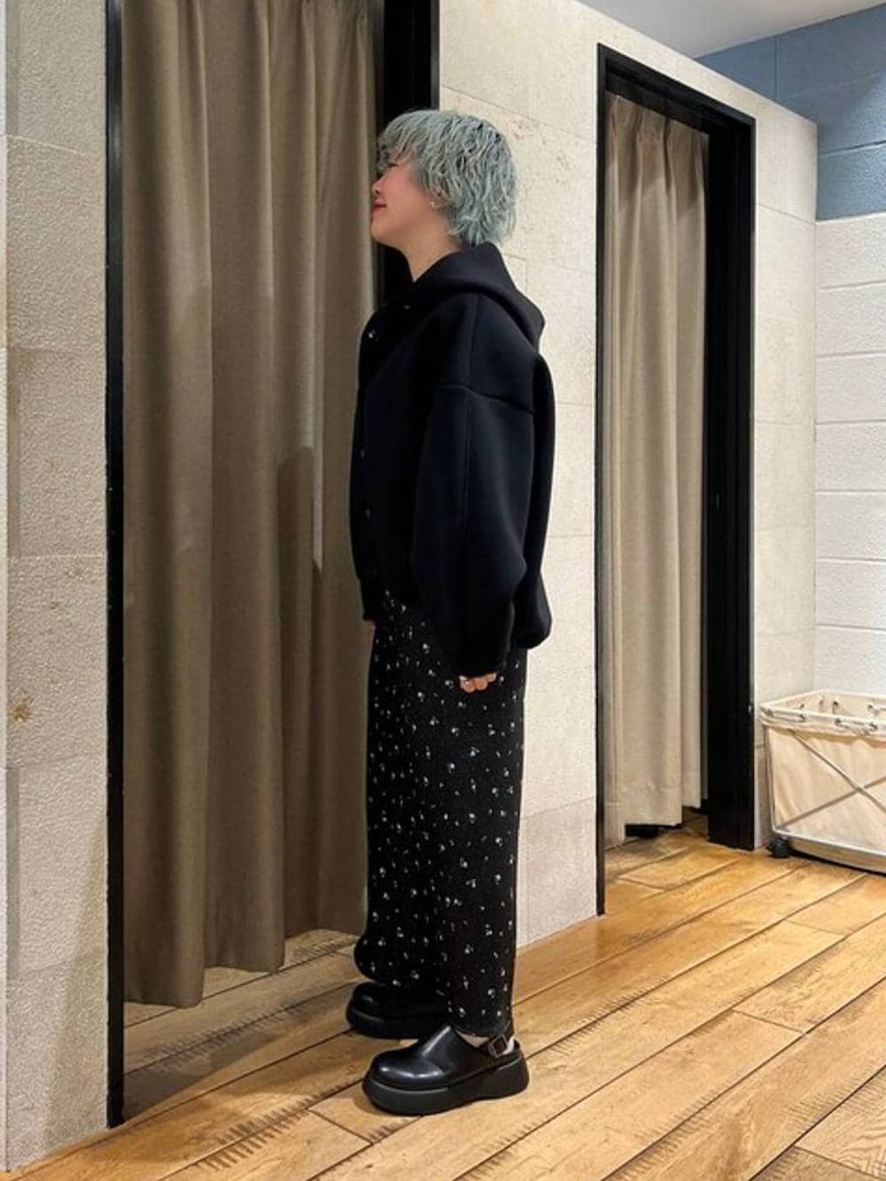 ブラック系のスカート、ブラック系のサンダル、ブラック系のブルゾンを着用したレディースの冬コーディネートの2枚目の写真