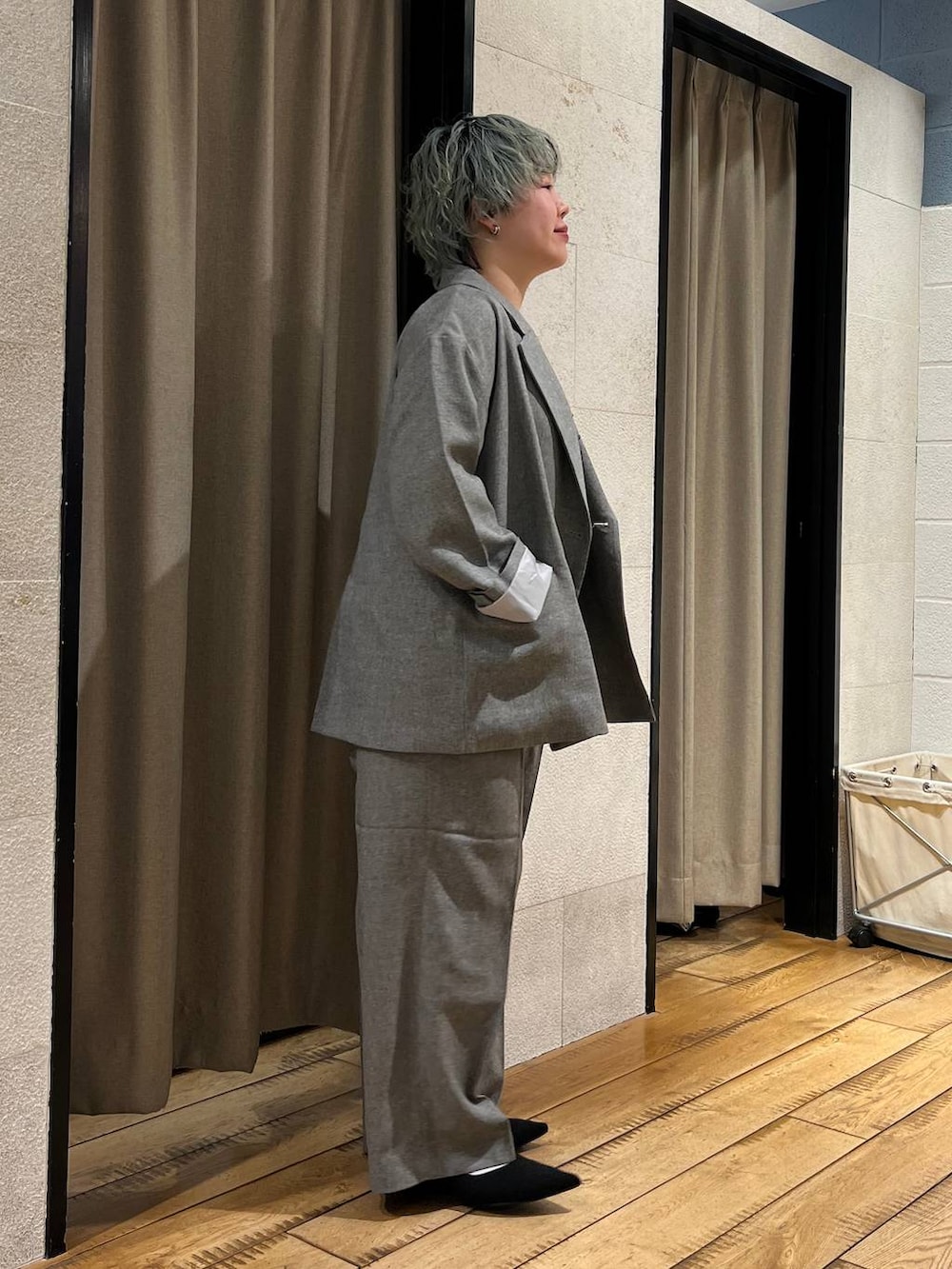 グレー系のテーラードジャケット、グレー系のデニムパンツ、ブラック系のパンプスを着用したレディースの春コーディネートの4枚目の写真