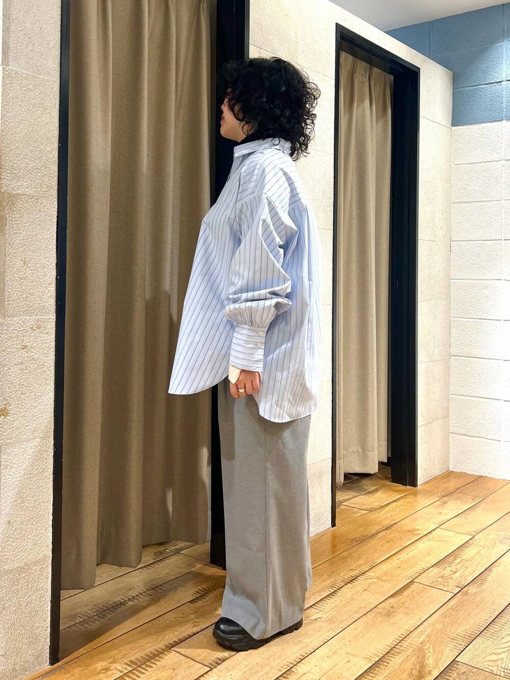 グレー系のサロペット/オーバーオール、ブラック系のブーツ、ブルー系のシャツ/ブラウスを着用したレディースの冬コーディネートの2枚目の写真