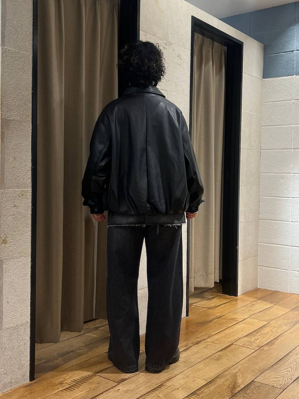 ブラック系のブーツ、ブラック系のデニムパンツ、ブラック系のデニムパンツを着用したレディースの秋コーディネートの3枚目の写真