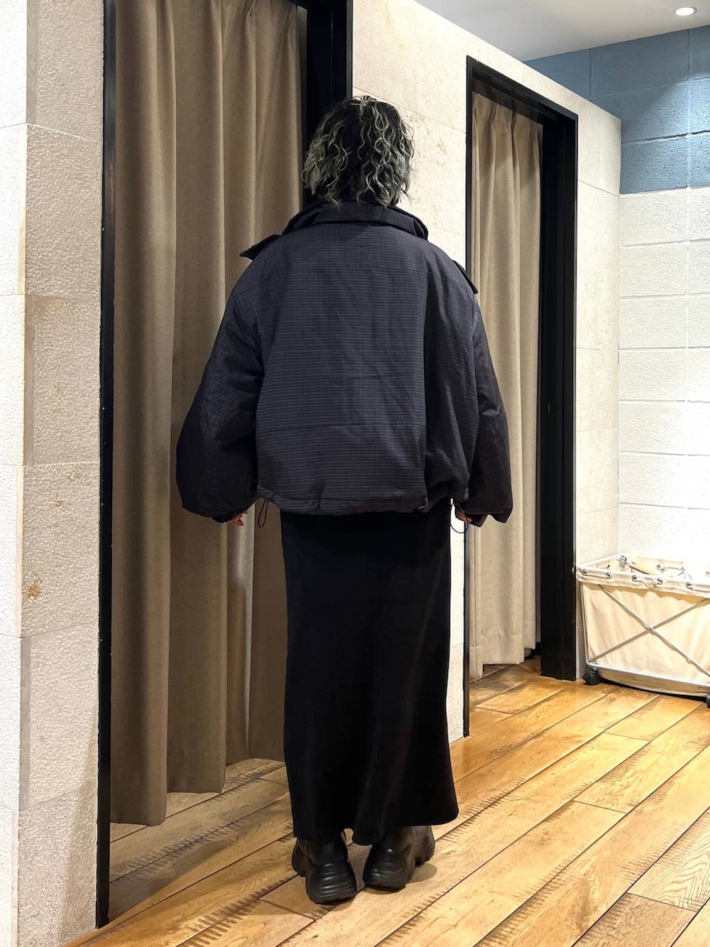 ブラック系のブーツ、ブラック系のスカート、グレー系のニット/セーターを着用したレディースの冬コーディネートの3枚目の写真