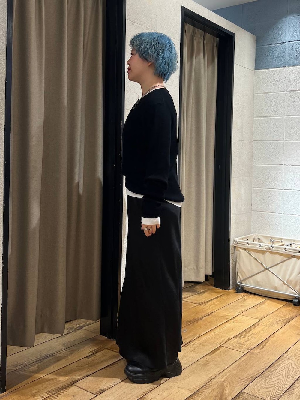 ブラック系のブーツ、ブラック系のスカート、ブラック系のニット/セーターを着用したレディースの冬コーディネートの2枚目の写真