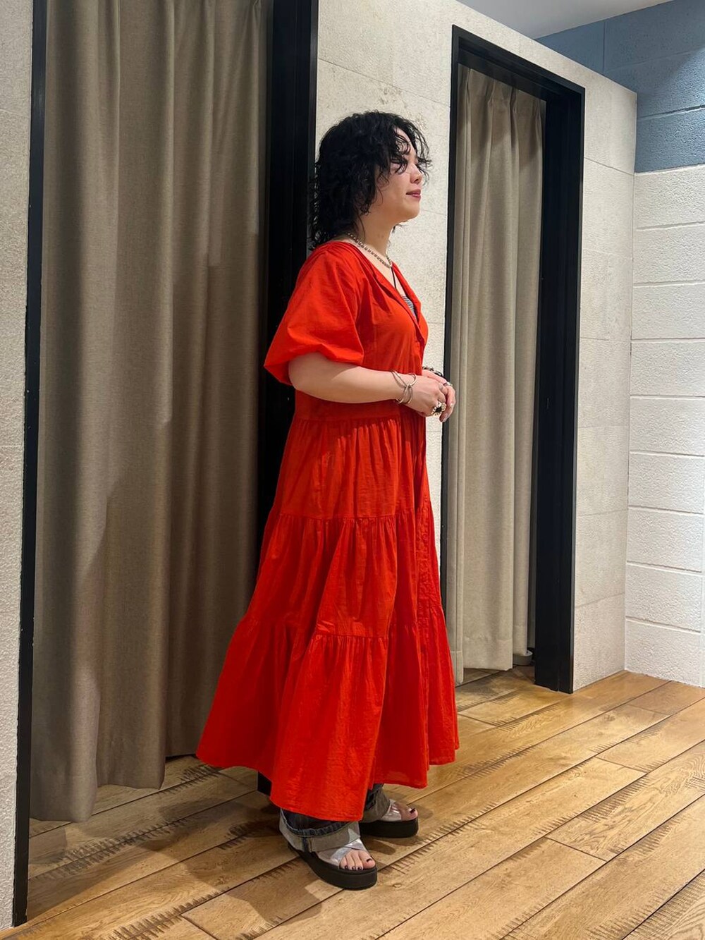 シルバー系のサンダル、レッド系のワンピース、ブルー系のデニムパンツを着用したレディースの春コーディネートの4枚目の写真