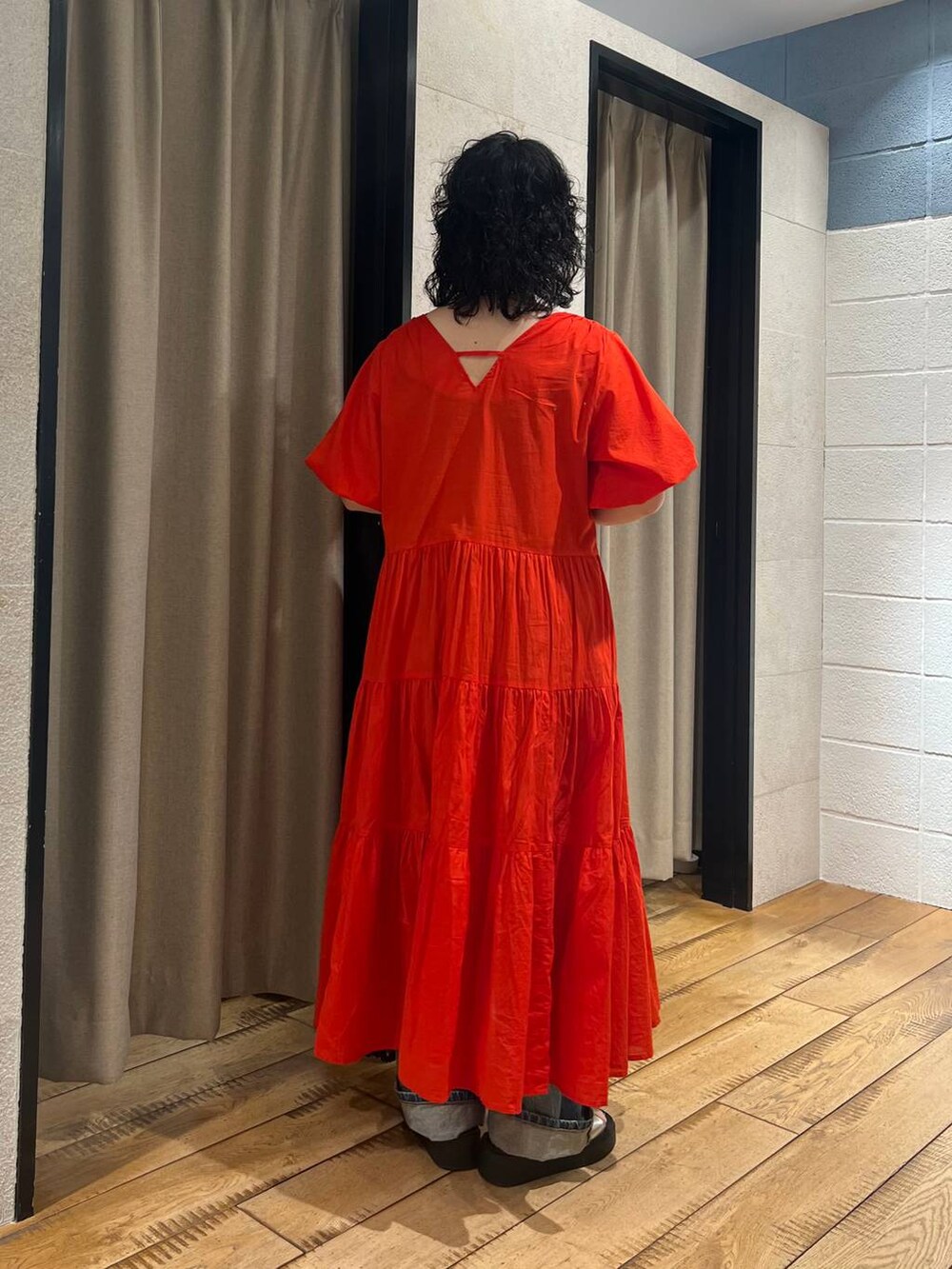 シルバー系のサンダル、レッド系のワンピース、ブルー系のデニムパンツを着用したレディースの春コーディネートの3枚目の写真