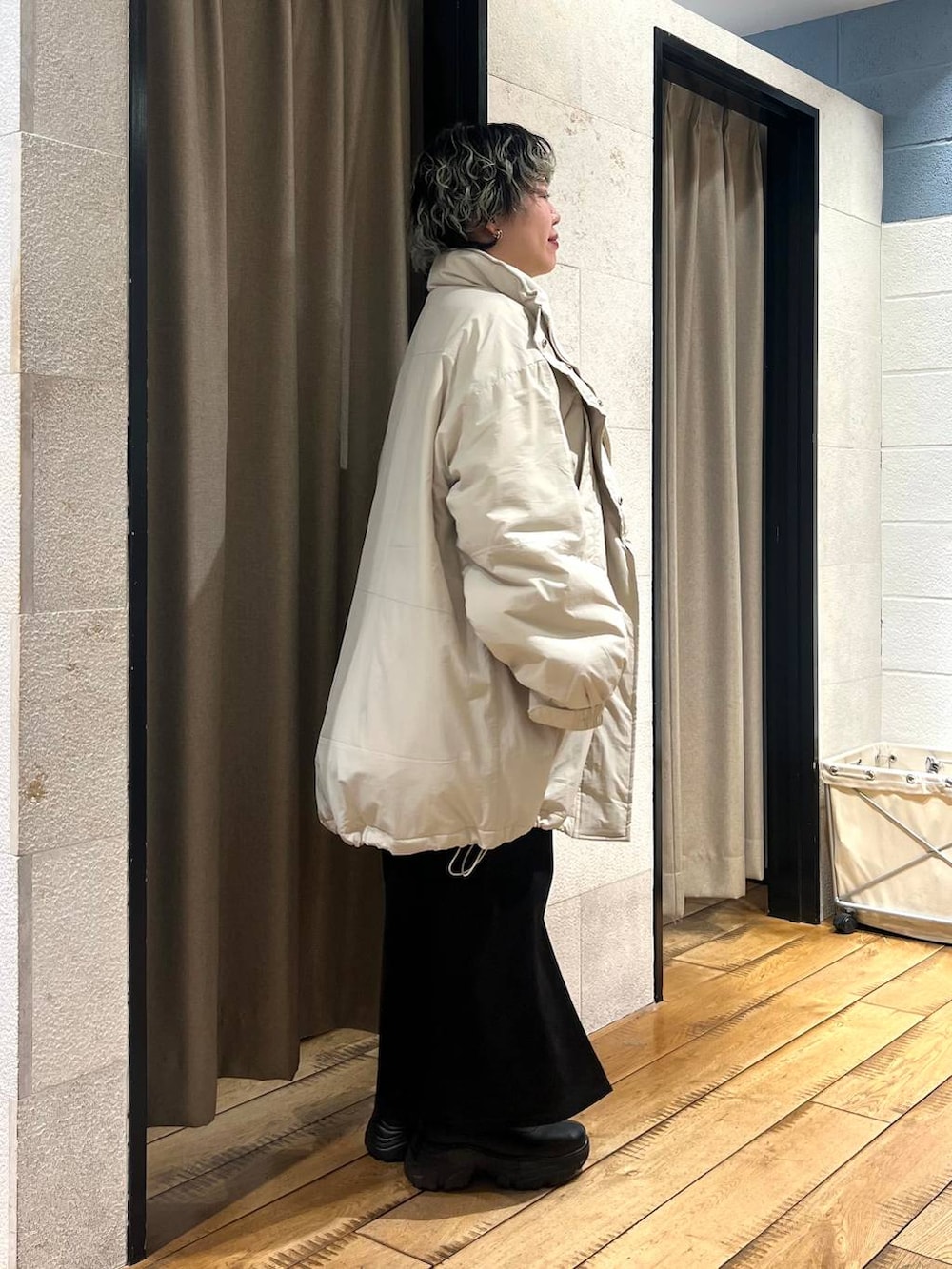 ブラック系のブーツ、ホワイト系のブルゾン、グリーン系のニット/セーターを着用したレディースの冬コーディネートの4枚目の写真