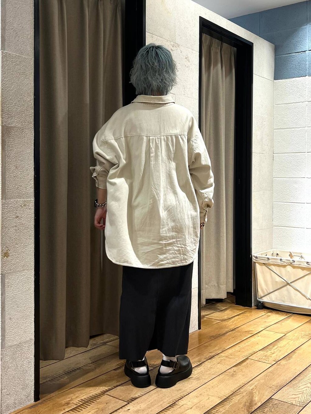 グレー系のスカート、ベージュ系のシャツ/ブラウス、ブラック系のサンダルを着用したレディースの冬コーディネートの3枚目の写真