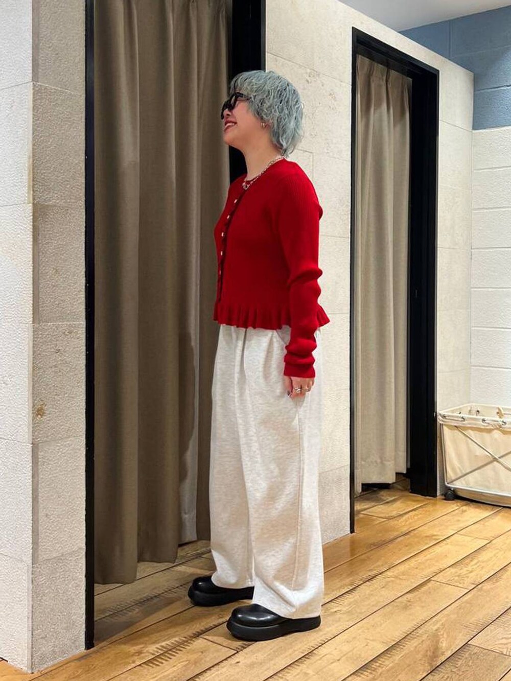 グレー系のスウェットパンツ、ブラック系のサンダル、レッド系のTシャツ/カットソーを着用したレディースの冬コーディネートの2枚目の写真