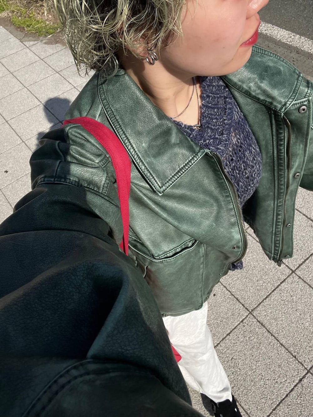 グレー系のスウェットパンツ、グリーン系のブルゾン、シルバー系のネックレスを着用したレディースの春コーディネートの3枚目の写真