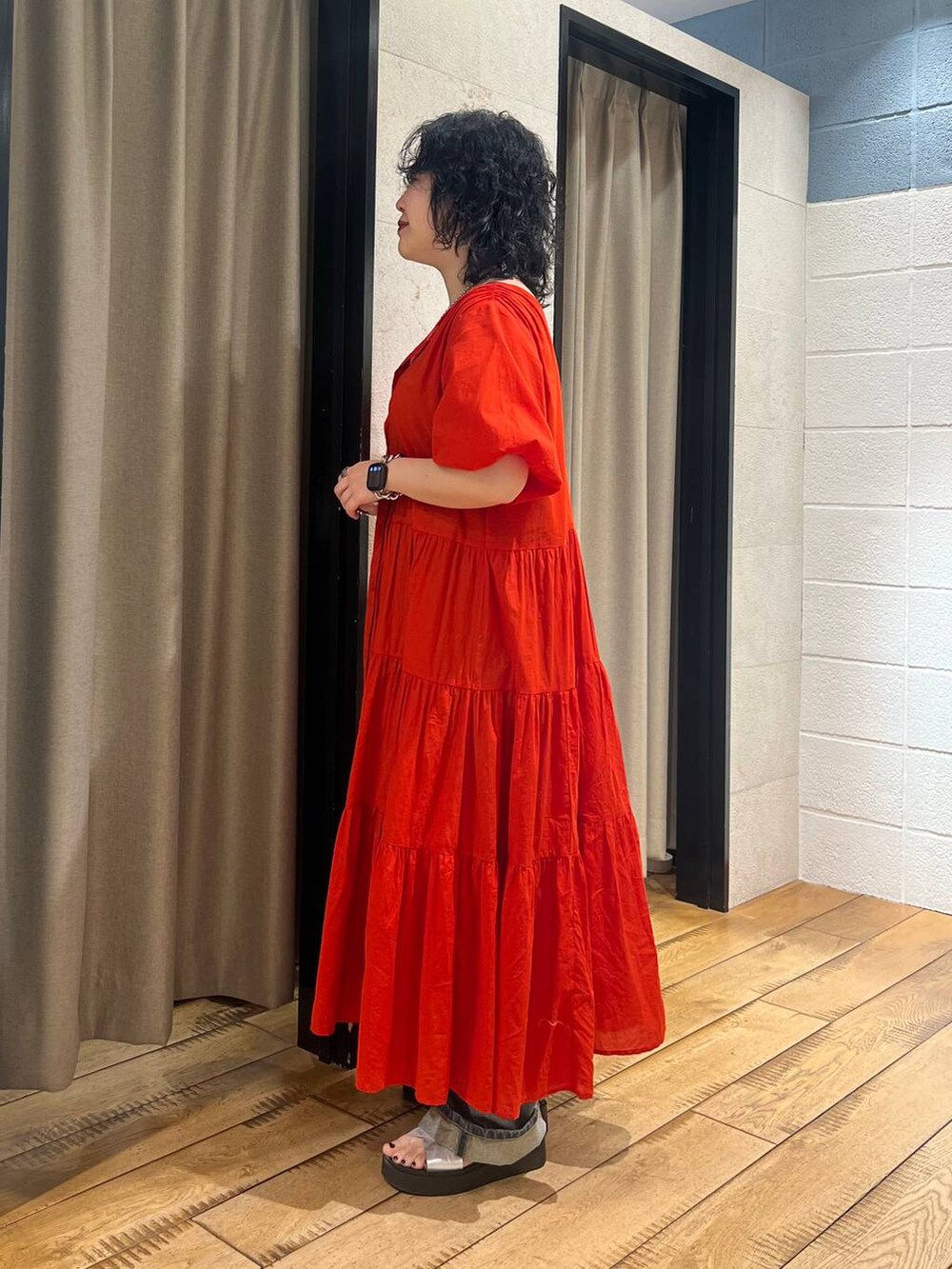 シルバー系のサンダル、レッド系のワンピース、ブルー系のデニムパンツを着用したレディースの春コーディネートの2枚目の写真