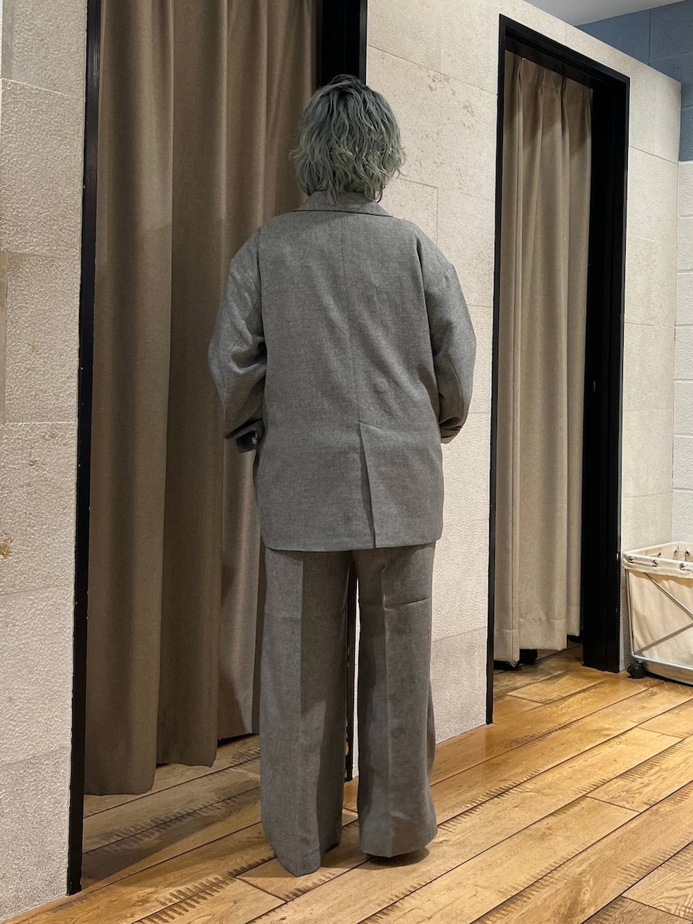 グレー系のテーラードジャケット、グレー系のデニムパンツ、ブラック系のパンプスを着用したレディースの春コーディネートの3枚目の写真