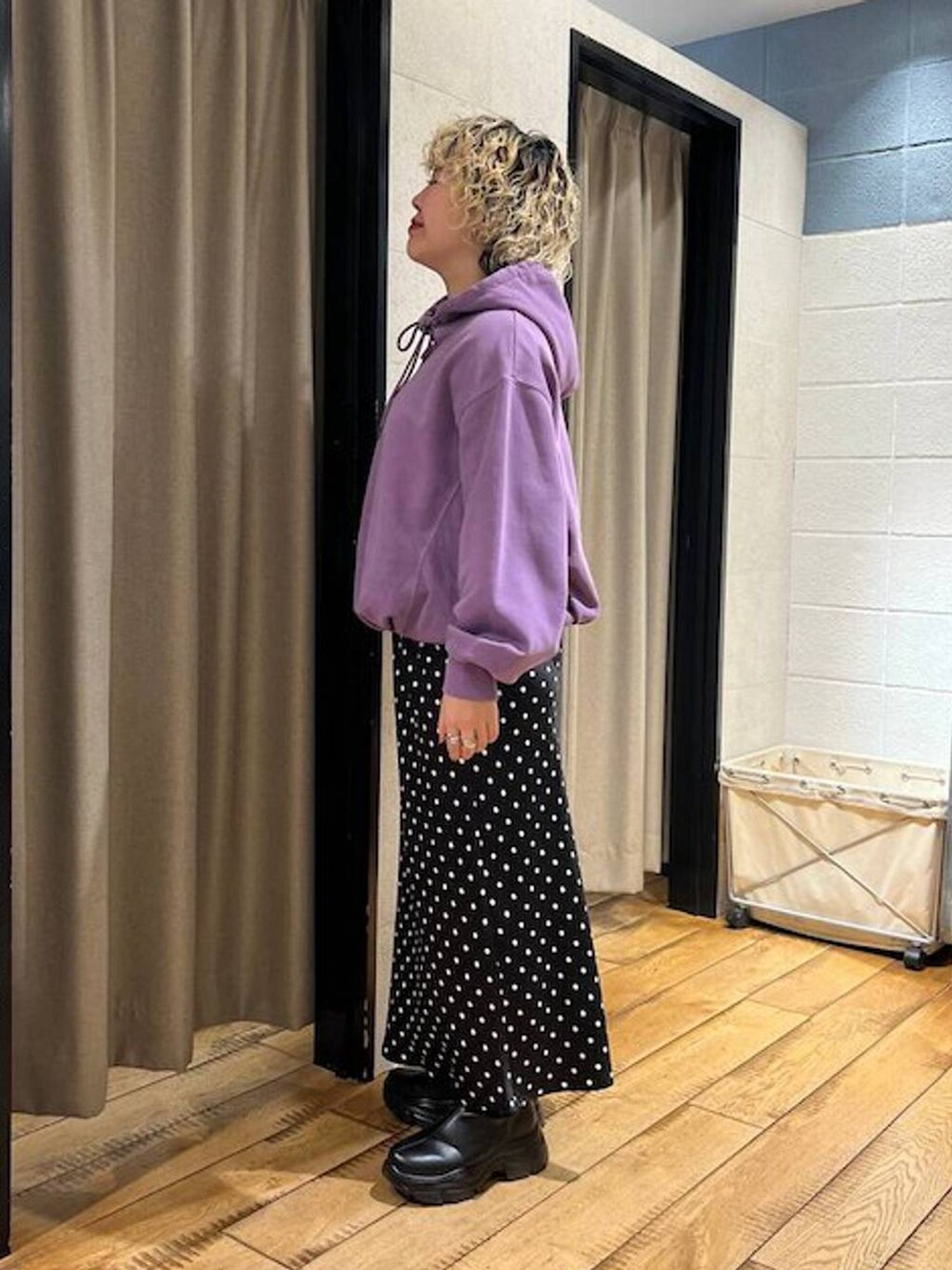 ブラック系のブーツ、ブラック系のスカート、パープル系のパーカーを着用したレディースの秋コーディネートの2枚目の写真