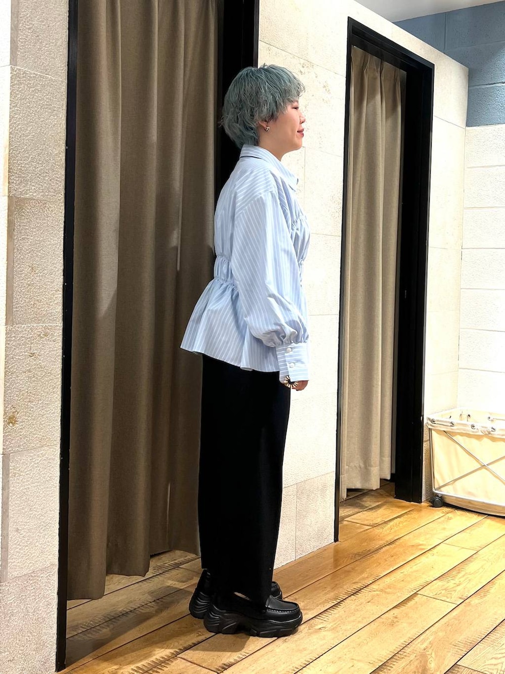 ブラック系のスカート、ブラック系のローファー、ブルー系のシャツ/ブラウスを着用したレディースの冬コーディネートの4枚目の写真