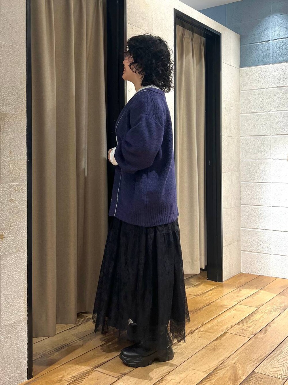 ブラック系のブーツ、ホワイト系のTシャツ/カットソー、ブルー系のカーディガン/ボレロを着用したレディースの冬コーディネートの2枚目の写真