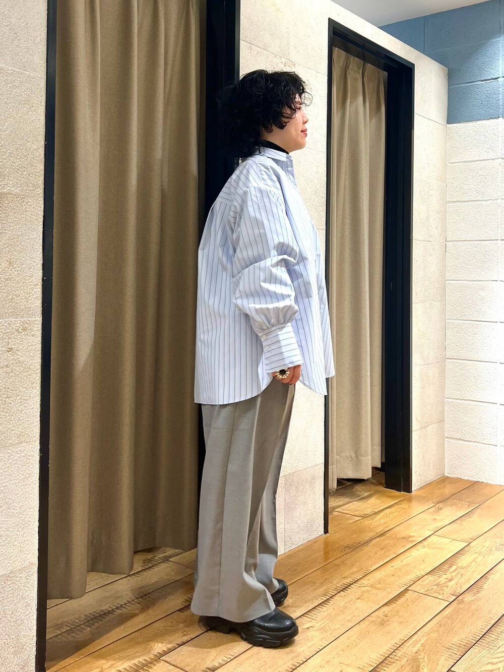 グレー系のサロペット/オーバーオール、ブラック系のブーツ、ブルー系のシャツ/ブラウスを着用したレディースの冬コーディネートの4枚目の写真