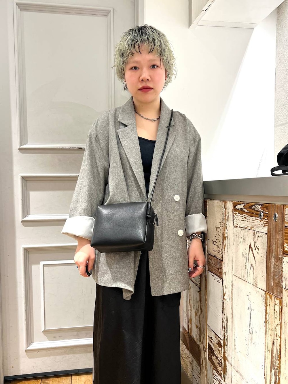 ブラック系のスカート、ブラック系のトートバッグ、グレー系のテーラードジャケットを着用したレディースの春コーディネートの3枚目の写真