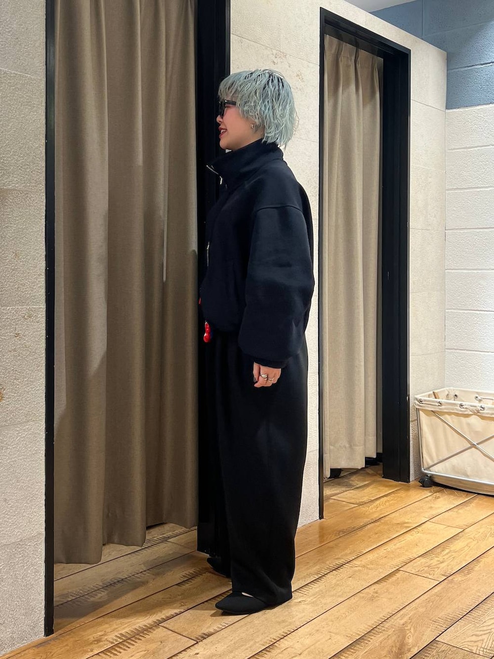 ブラック系のスウェットパンツ、ブラック系のパンプス、レッド系のボディバッグ/ウエストポーチを着用したレディースの冬コーディネートの2枚目の写真