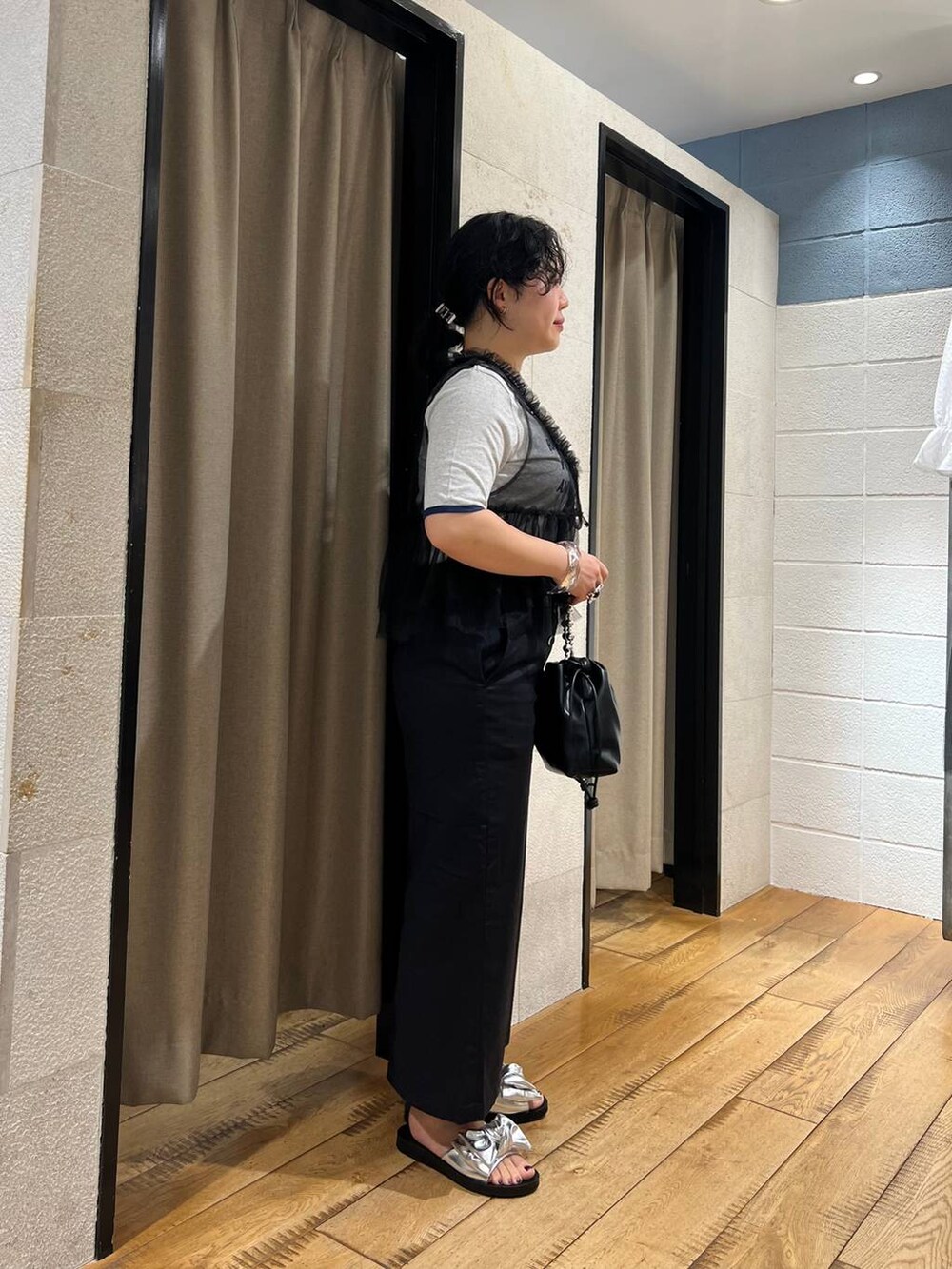 グレー系のTシャツ/カットソー、ブラック系のスカート、ブラック系のショルダーバッグを着用したレディースの夏コーディネートの4枚目の写真