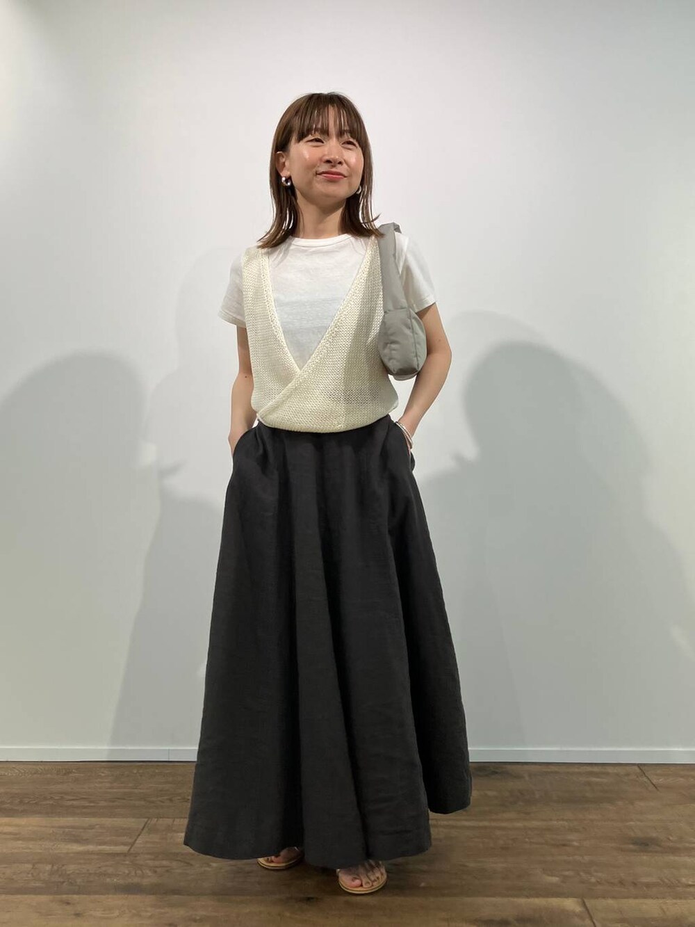 グリーン系のショルダーバッグ、グレー系のスカート、ホワイト系のTシャツ/カットソーを着用したレディースの春コーディネートの4枚目の写真