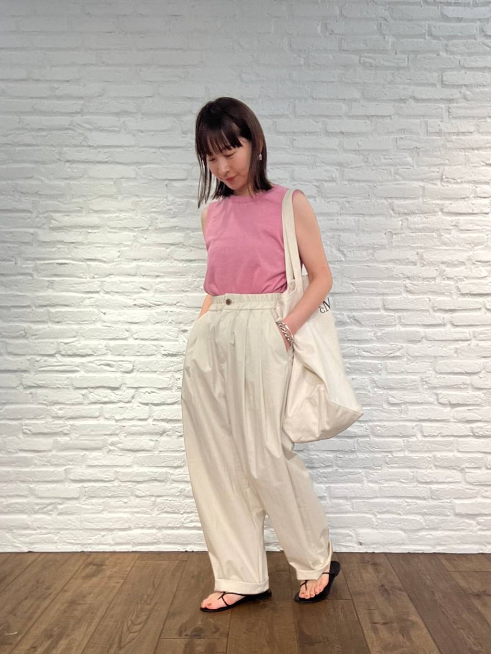 ピンク系のタンクトップ、ホワイト系のその他パンツ、ブラック系のサンダルを着用したレディースの春コーディネートの2枚目の写真