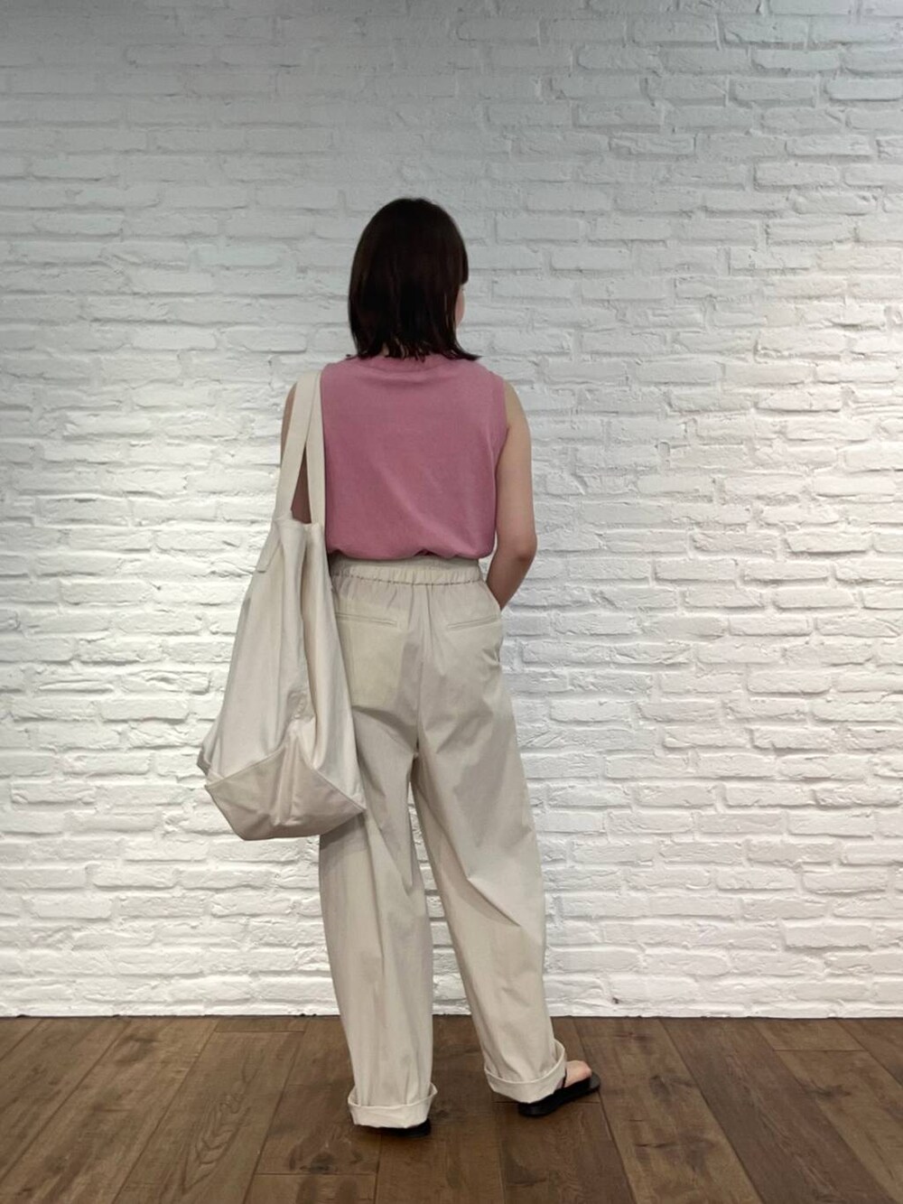 ピンク系のタンクトップ、ホワイト系のその他パンツ、ブラック系のサンダルを着用したレディースの春コーディネートの3枚目の写真