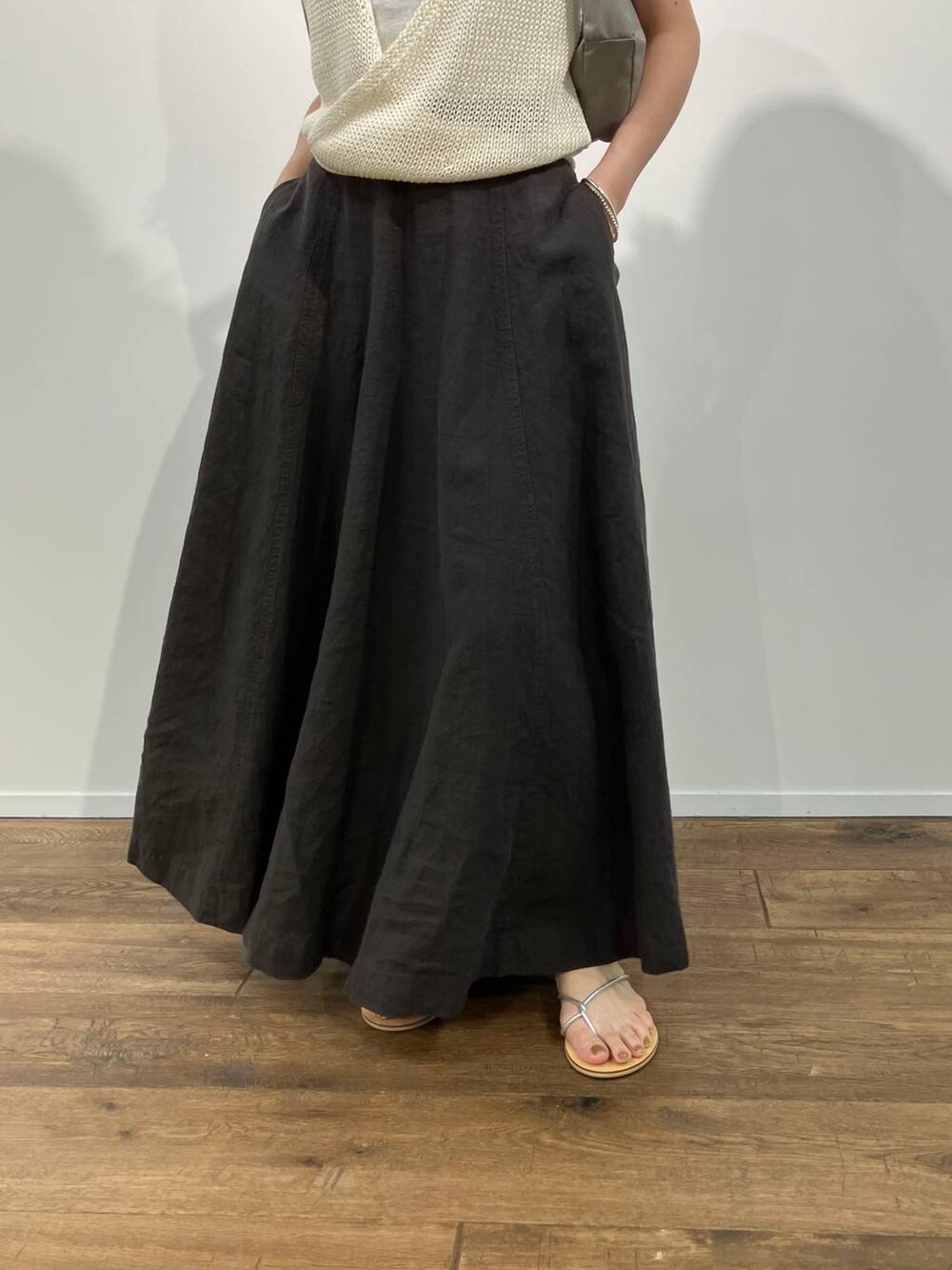 グリーン系のショルダーバッグ、グレー系のスカート、ホワイト系のTシャツ/カットソーを着用したレディースの春コーディネートの6枚目の写真