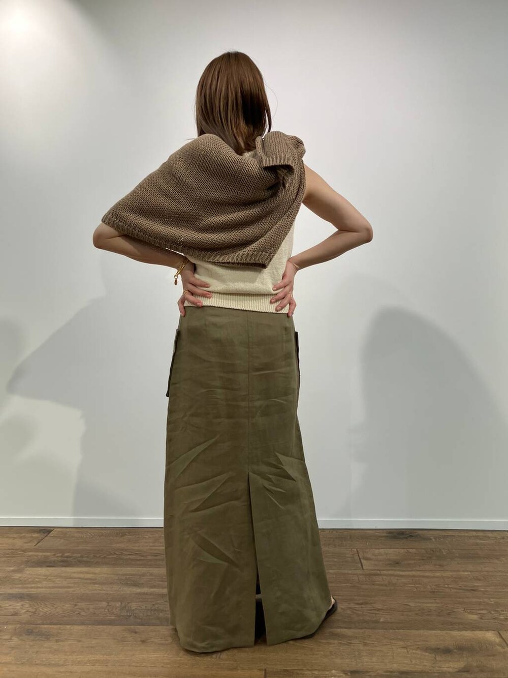 ベージュ系のニット/セーター、ベージュ系のタンクトップ、ブラック系のサンダルを着用したレディースの春コーディネートの2枚目の写真