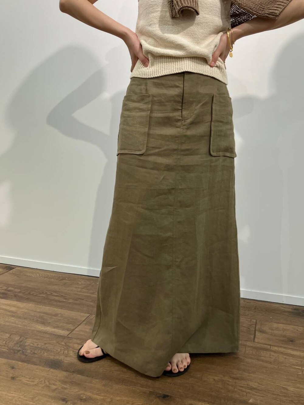 ベージュ系のニット/セーター、ベージュ系のタンクトップ、ブラック系のサンダルを着用したレディースの春コーディネートの5枚目の写真