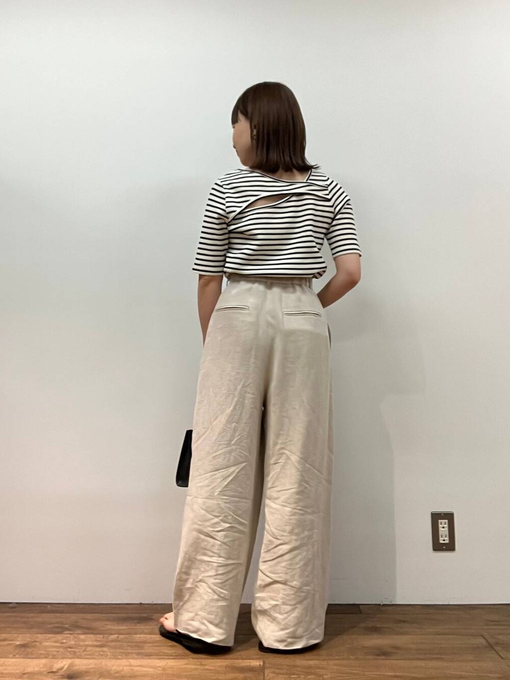 ホワイト系のTシャツ/カットソー、ベージュ系のその他パンツ、ブラック系のショルダーバッグを着用したレディースの春コーディネートの3枚目の写真