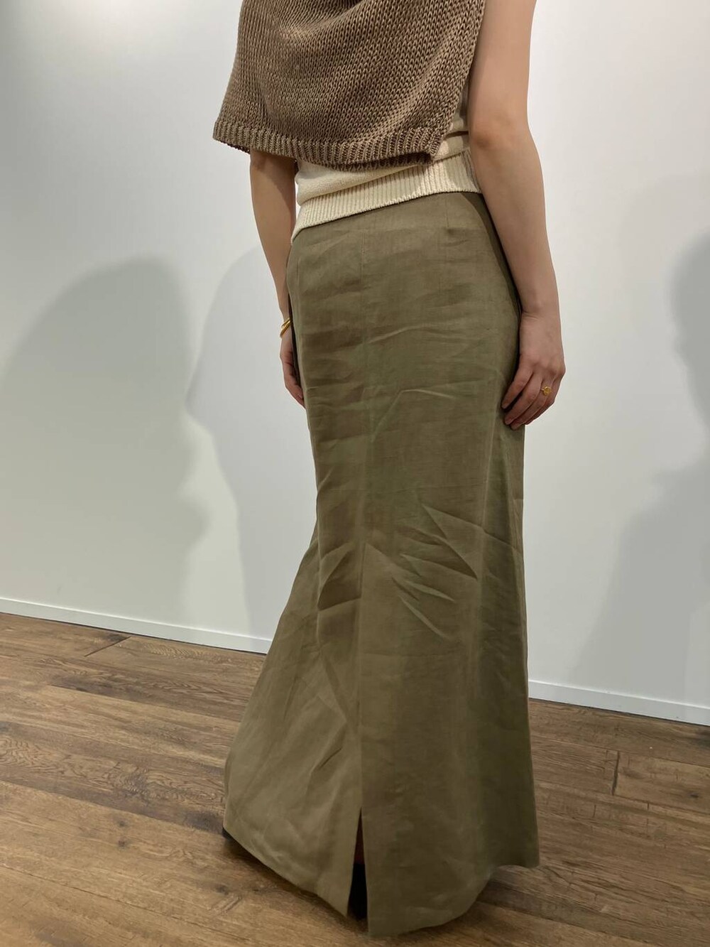 ベージュ系のニット/セーター、ベージュ系のタンクトップ、ブラック系のサンダルを着用したレディースの春コーディネートの6枚目の写真