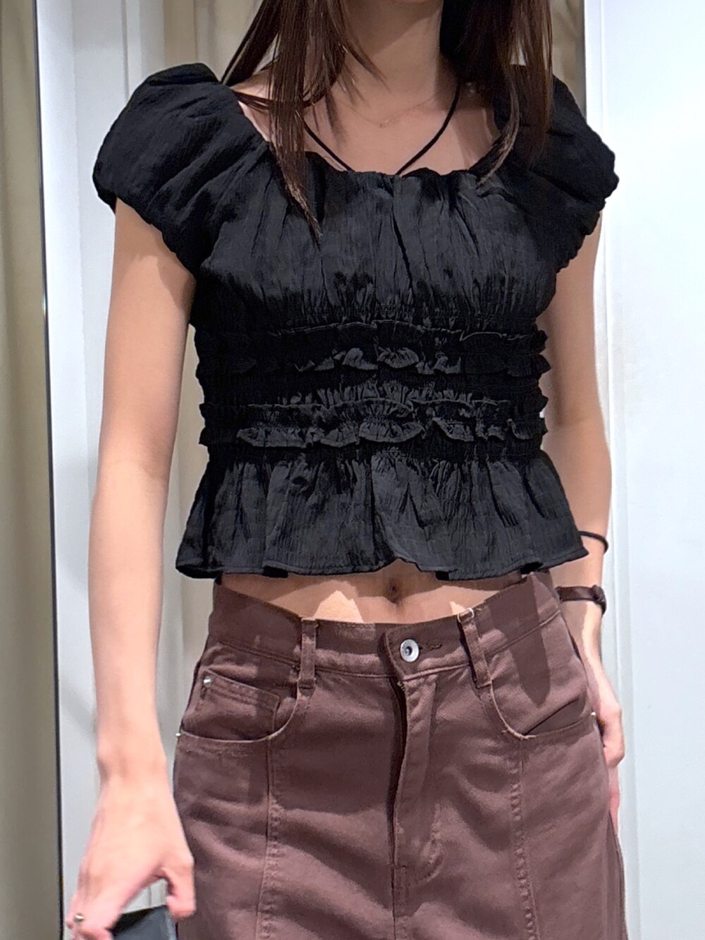 ブラウン系のデニムパンツ、ブラック系のハンドバッグ、ブラック系のシャツ/ブラウスを着用したレディースの夏コーディネートの3枚目の写真